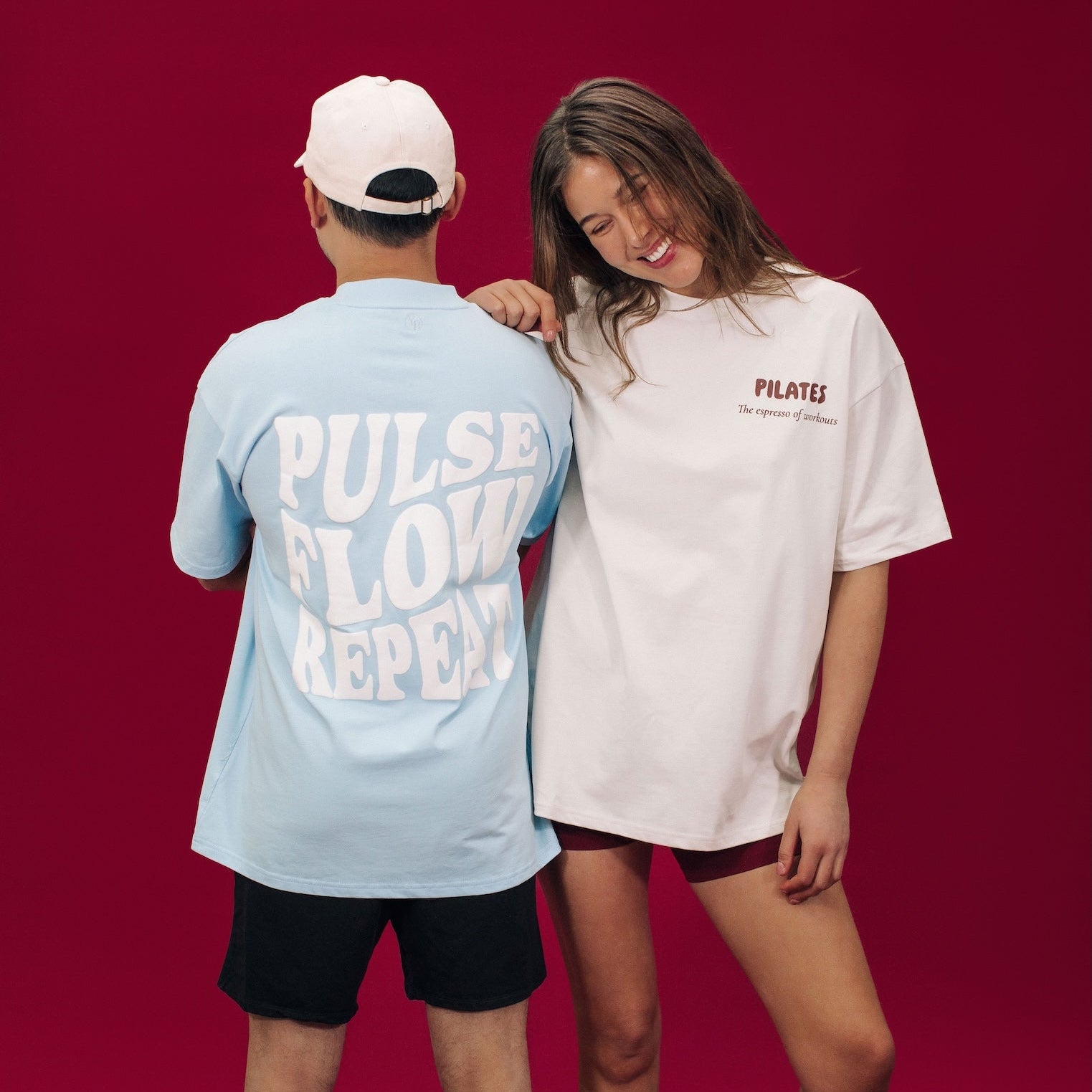 Two people wearing t-shirts with text on a red background