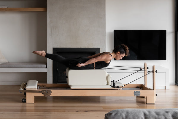 Maple Wood Studio Pilates Reformer - Woman Exercising Side Profile | Your Reformer