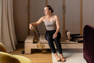 Maple Wood Studio Reformer - Woman Seated Exercise Side View | Your Reformer